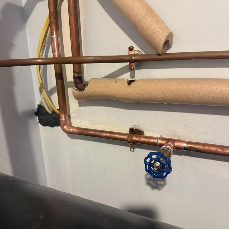 Copper water pipe with blue valve and insulation damage