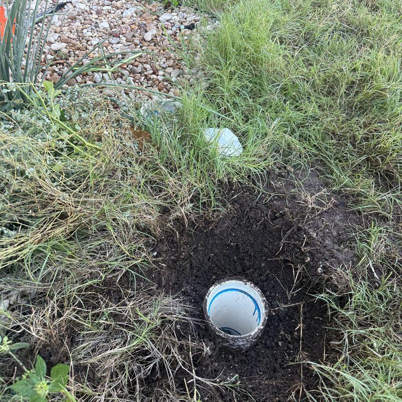 Sewer line cleanout pipe in dug soil patch