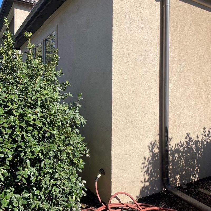 Stucco exterior wall with fresh finish and downspout Stucco exterior wall with fresh finish and downspout