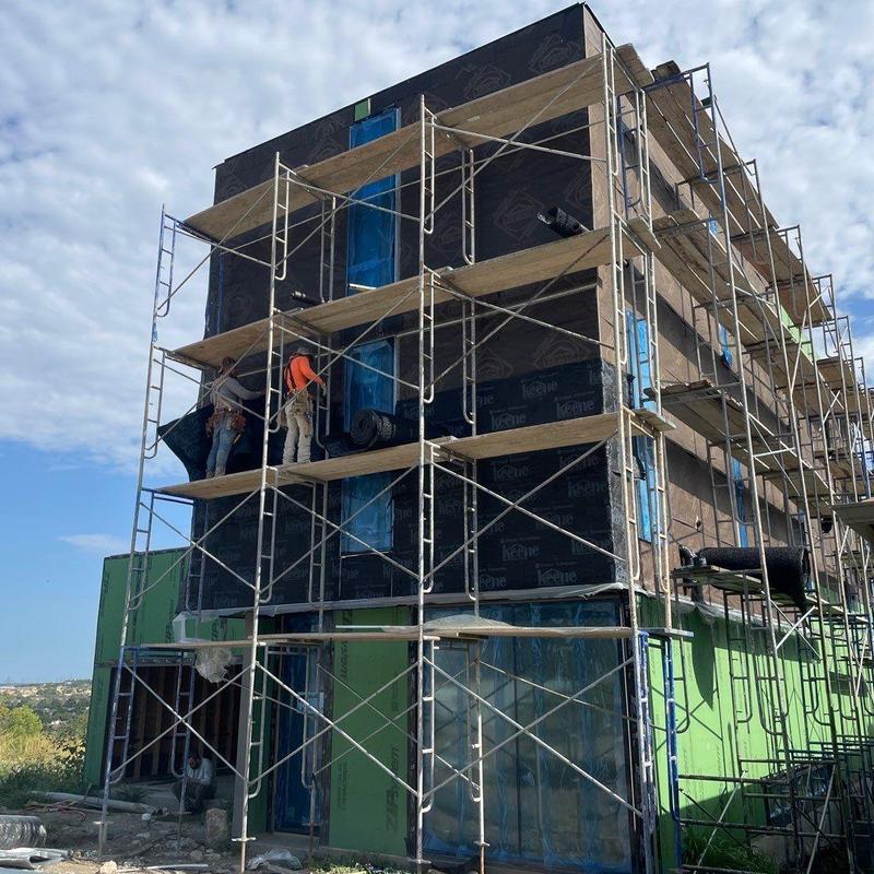 Stucco exterior installation with scaffolding on modern home Stucco exterior installation with scaffolding on modern home