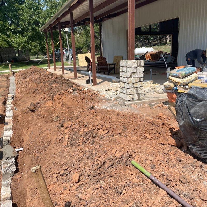 Stone retaining wall foundation with outdoor patio area Stone retaining wall foundation with outdoor patio area