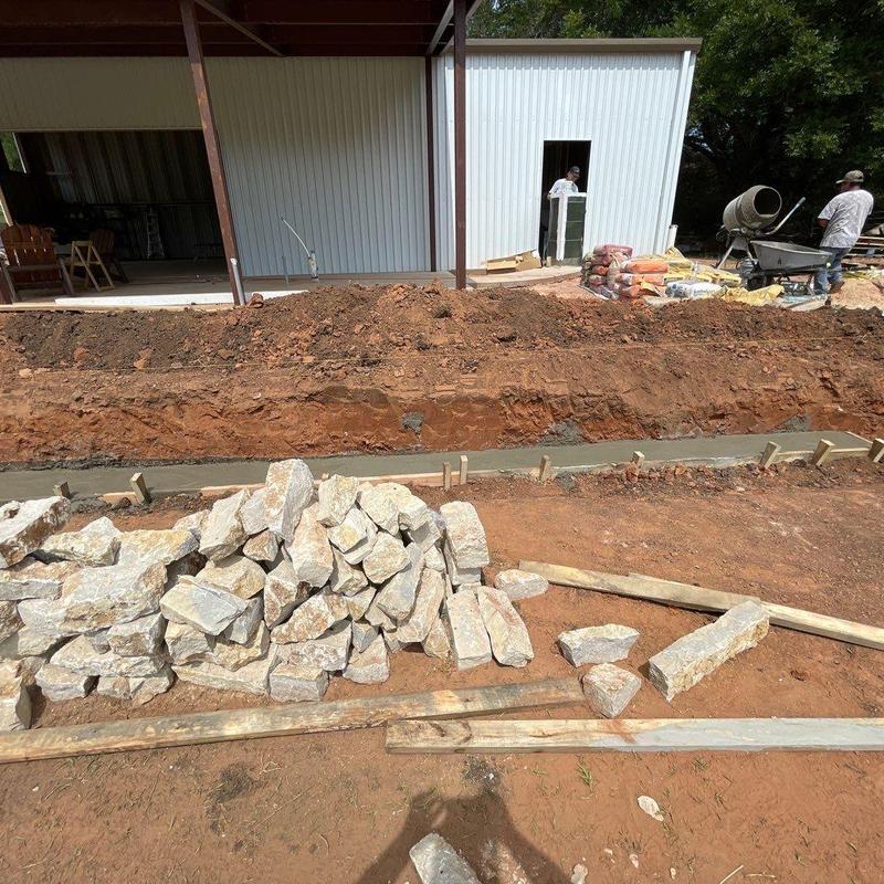 Stone retaining wall foundation with rock pile and cement Stone retaining wall foundation with rock pile and cement