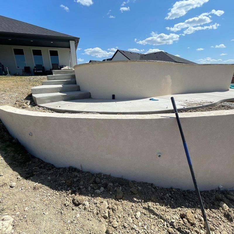 Concrete block retaining wall under construction beside pool Concrete block retaining wall under construction beside pool