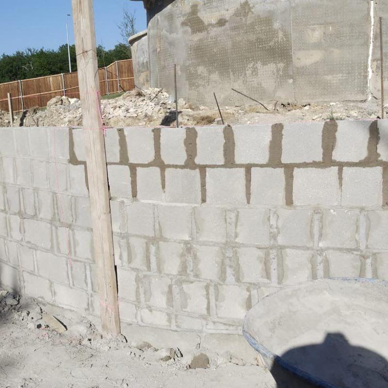 Concrete block retaining wall under construction near pool Concrete block retaining wall under construction near pool