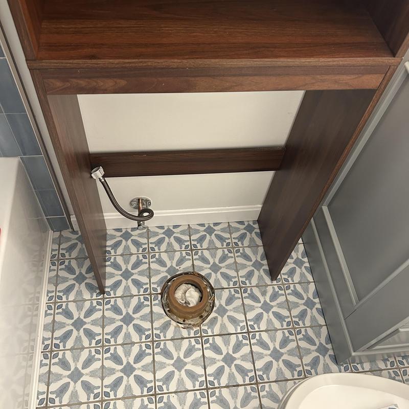 Toilet flange on tiled bathroom floor with supply line Toilet flange on tiled bathroom floor with supply line