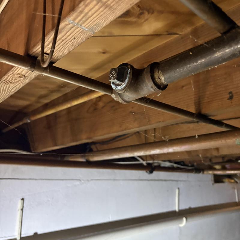Gas pipe capped under basement ceiling near wood beams