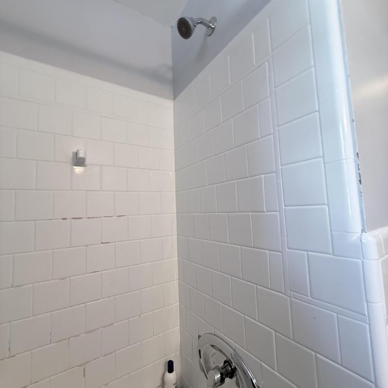 Moen shower valve and white tiled shower walls