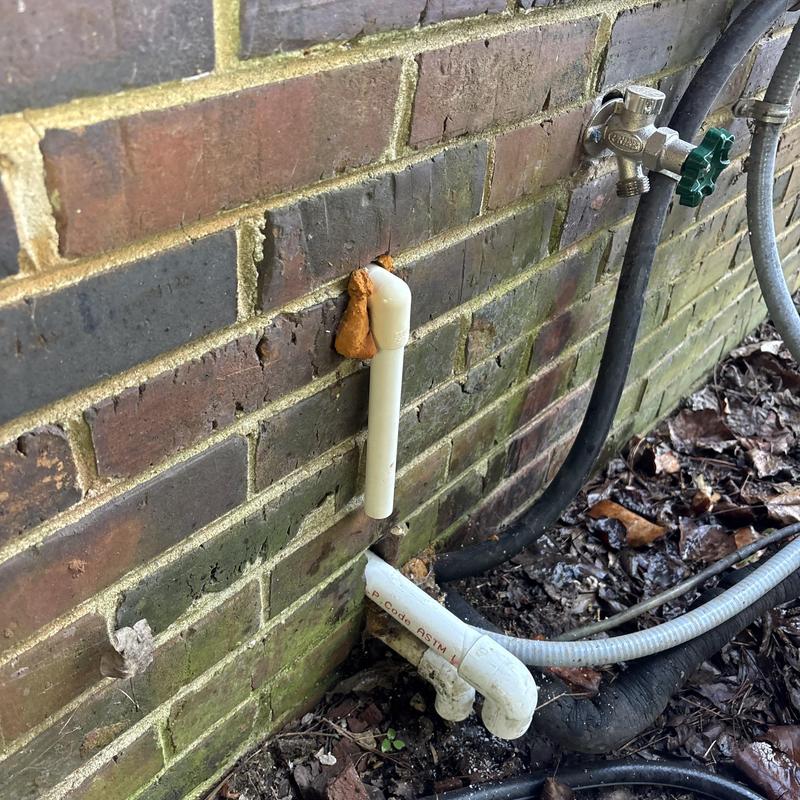PVC drain pipe and outdoor faucet on brick wall PVC drain pipe and outdoor faucet on brick wall
