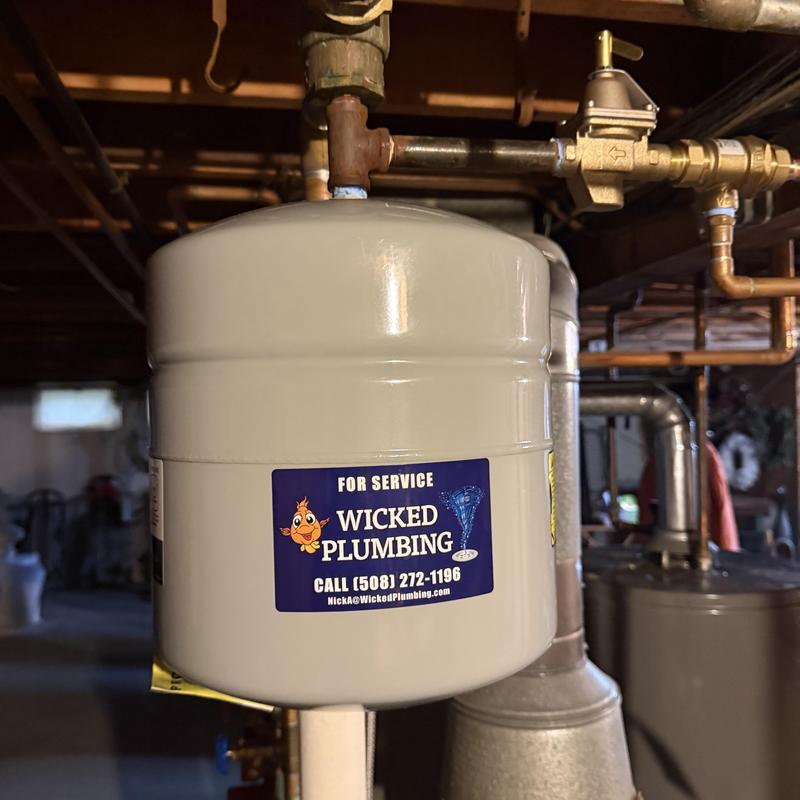 Boiler expansion tank with plumbing connections in basement