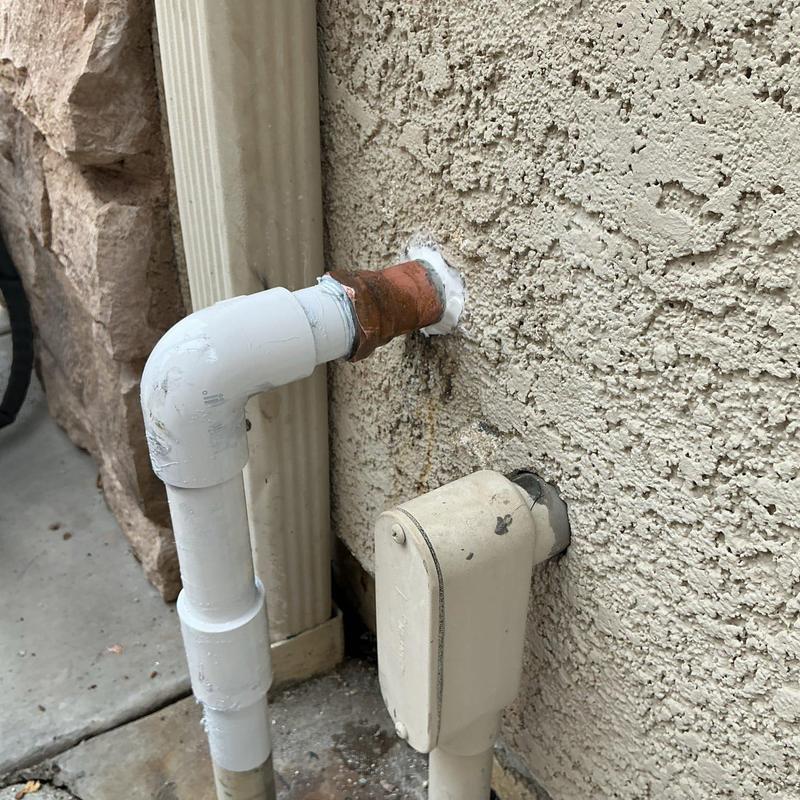 1-inch copper and PVC piping with elbow fitting at wall