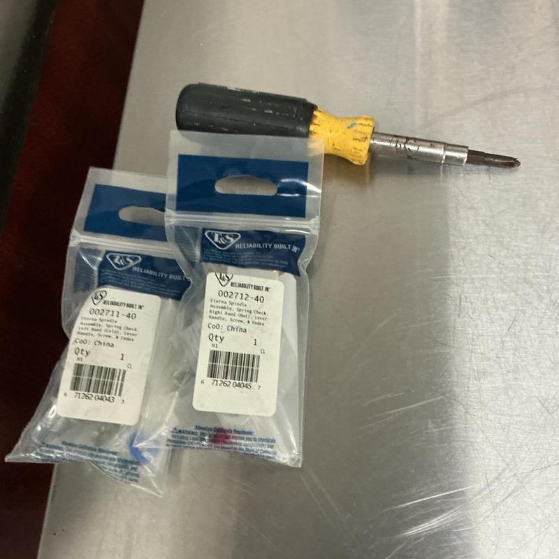 Faucet stem replacement parts with screwdriver on metal table Faucet stem replacement parts with screwdriver on metal table