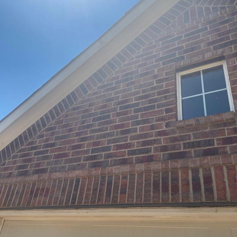 Brick exterior wall and window masonry work under blue sky Brick exterior wall and window masonry work under blue sky
