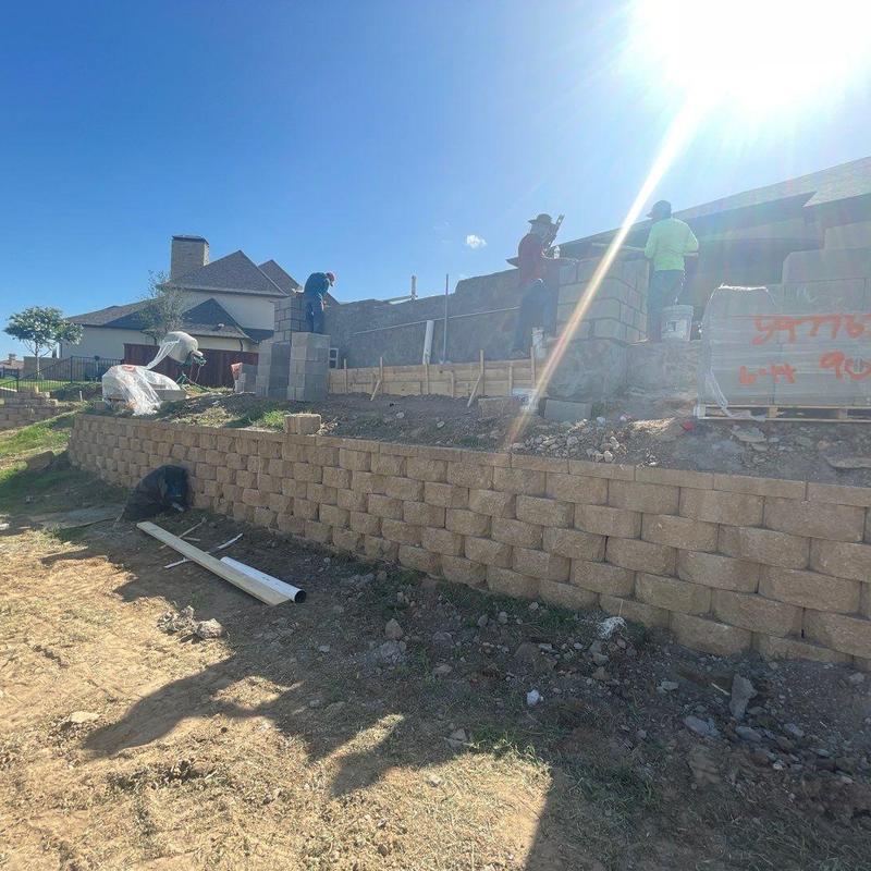 Block retaining wall construction on sloped backyard Block retaining wall construction on sloped backyard