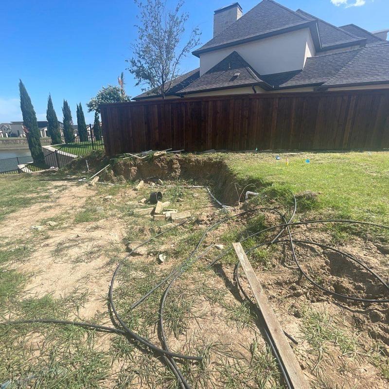 Backyard trench digging with exposed cables and dirt mound Backyard trench digging with exposed cables and dirt mound