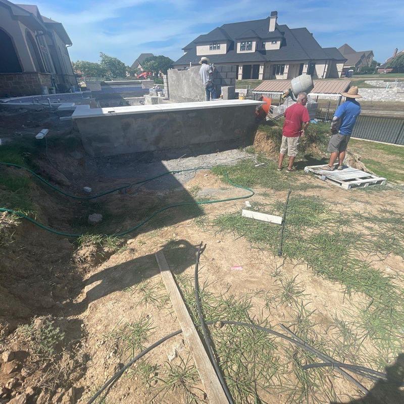 Block retaining wall construction on sloped backyard Block retaining wall construction on sloped backyard