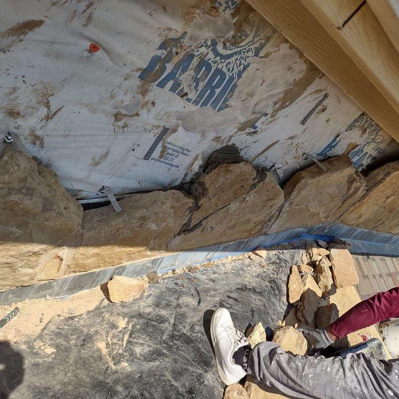 Exterior stone veneer installation along wall base Exterior stone veneer installation along wall base