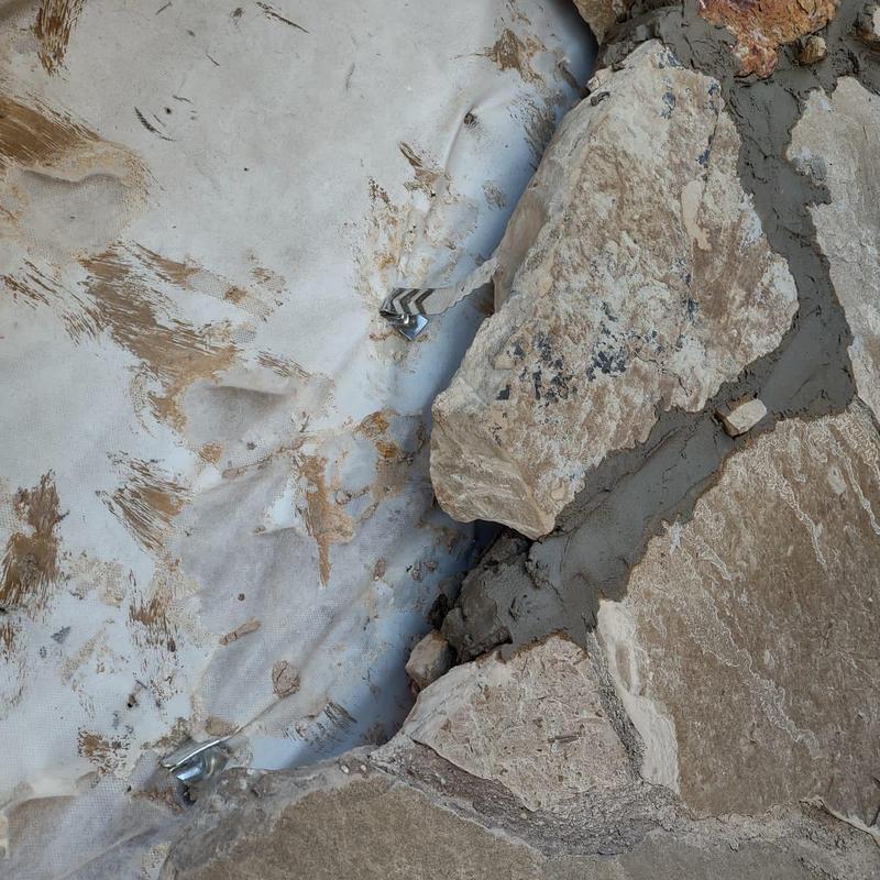 Exterior stone veneer repair with mortar filling Exterior stone veneer repair with mortar filling