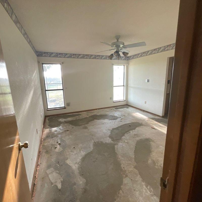 Concrete subfloor in living room remodel prep with ceiling fan Concrete subfloor in living room remodel prep with ceiling fan