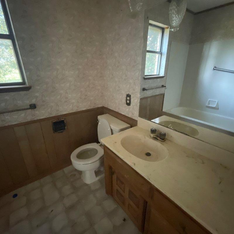 Bathroom vanity and toilet in dated condition Bathroom vanity and toilet in dated condition