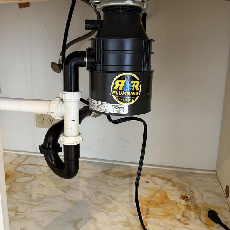 Garbage disposal unit with plumbing connections installed