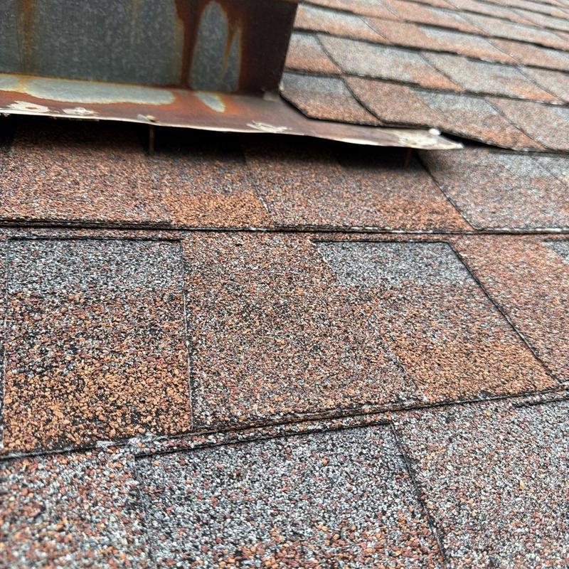 Asphalt shingle roof with rusted flashing detail