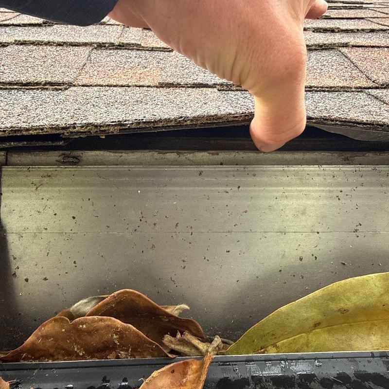 Roof shingles lifted exposing damaged flashing and debris