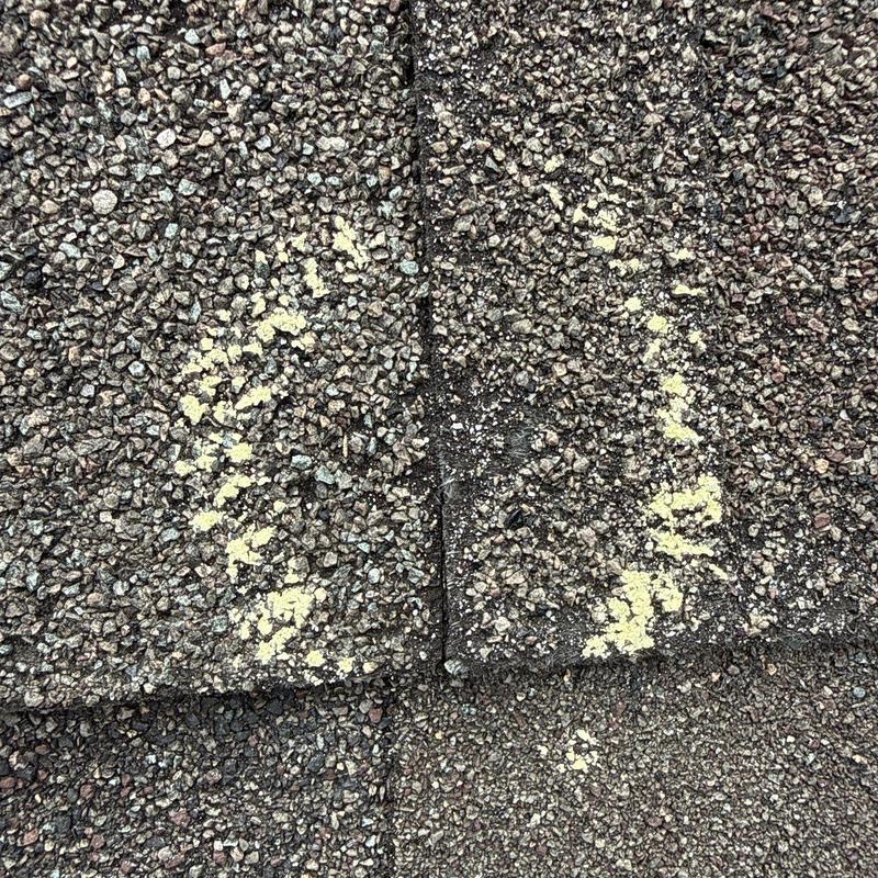 Asphalt shingles with marked hail damage on roof surface