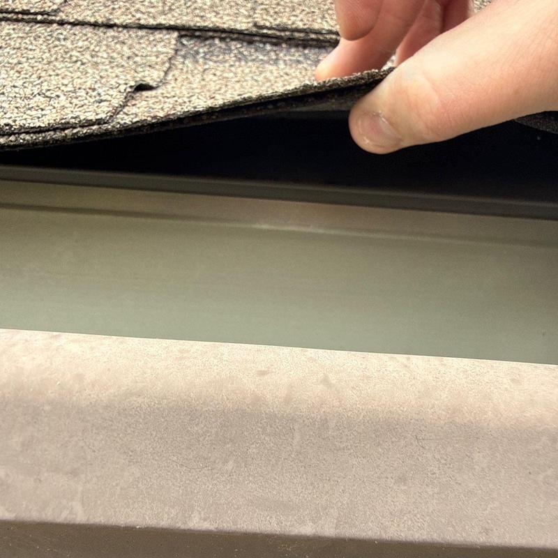Asphalt shingle roof edge lifted for inspection