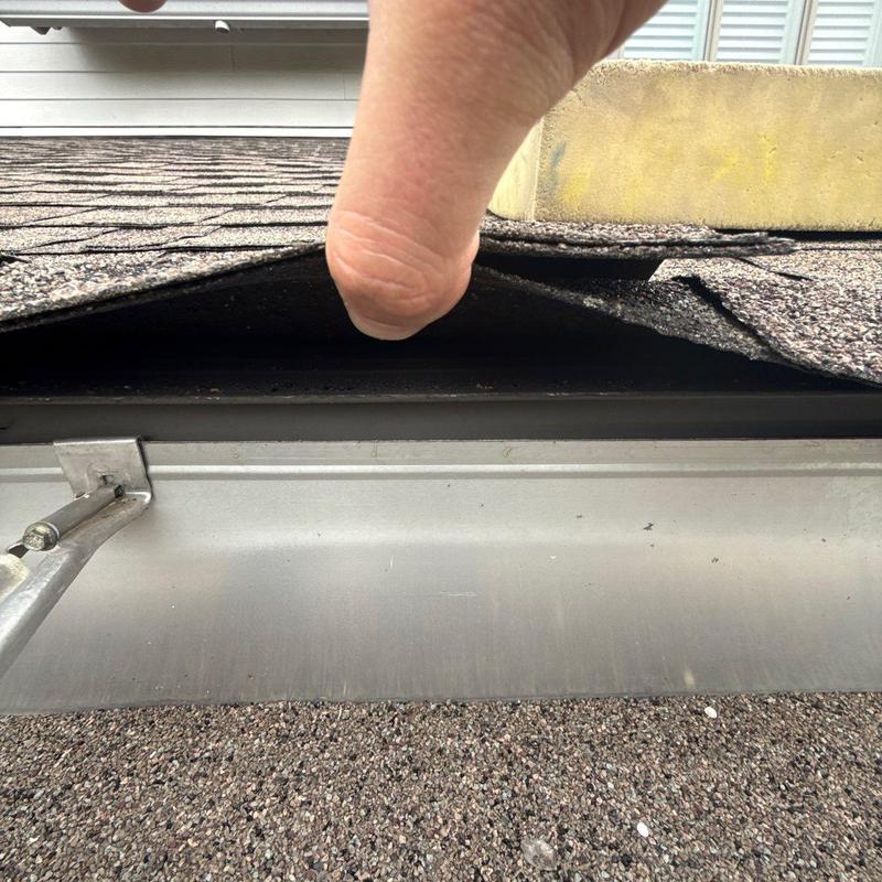 Roof shingles lifted showing potential damage underlayment