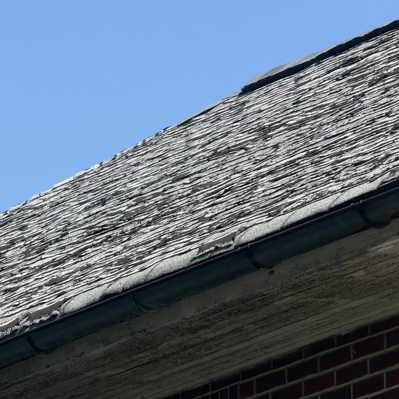 Asphalt shingle roof with severe weather damage