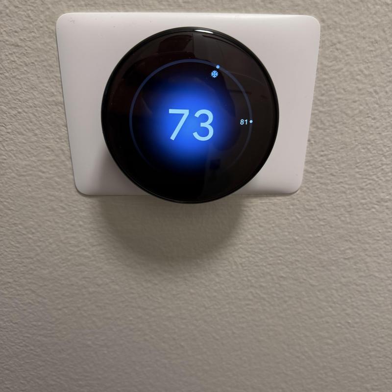Smart thermostat with temperature display on wall