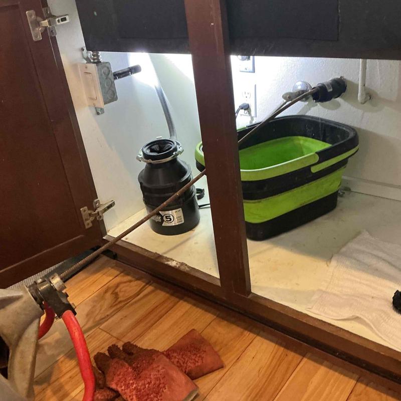 Kitchen drain line with snake tool clearing blockage