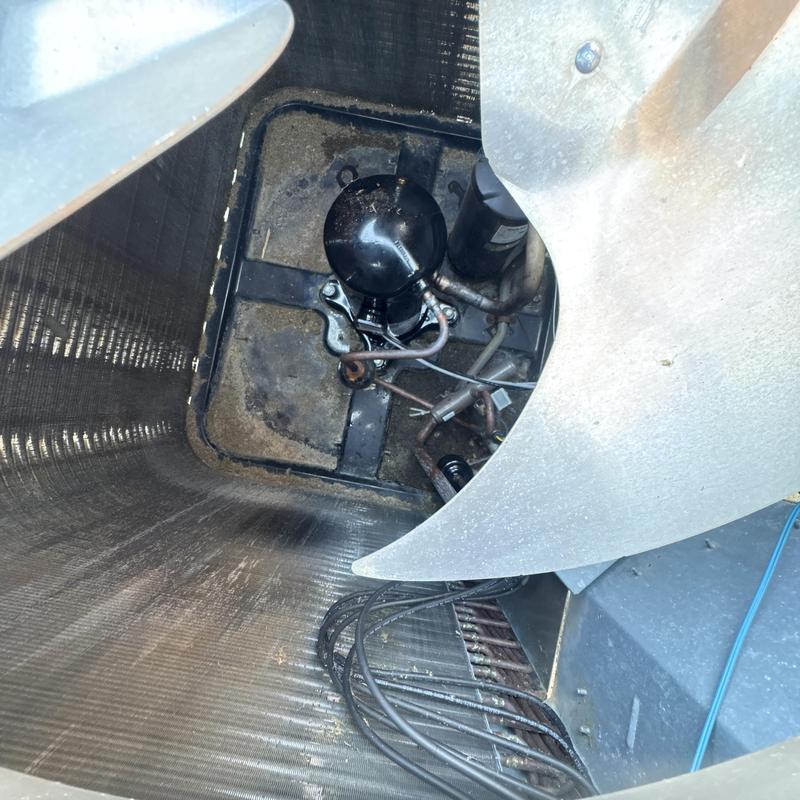 Compressor unit inside HVAC condenser coil with fan blades Compressor unit inside HVAC condenser coil with fan blades
