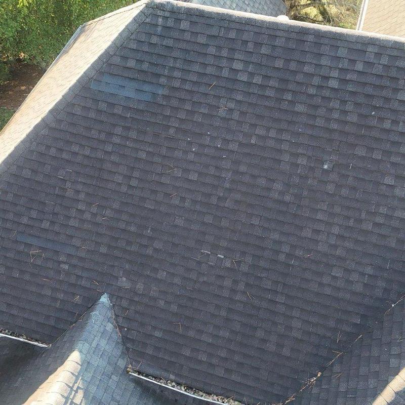 Asphalt shingle roof with displaced shingles and debris Asphalt shingle roof with displaced shingles and debris