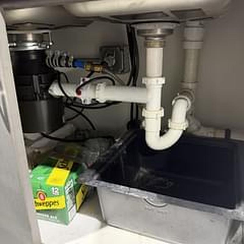 Sink drain pipes and garbage disposal under cabinet