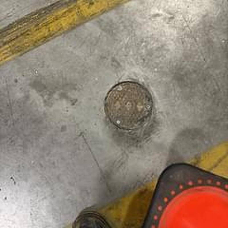 Main warehouse floor drain with inspection cone nearby