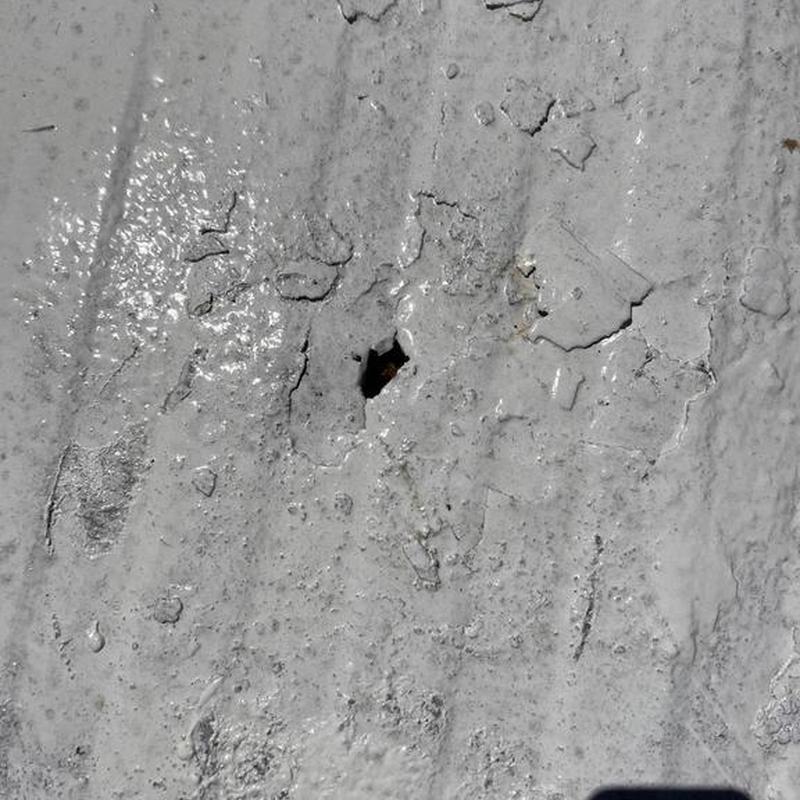 Silicone roofing coating with surface damage and hole