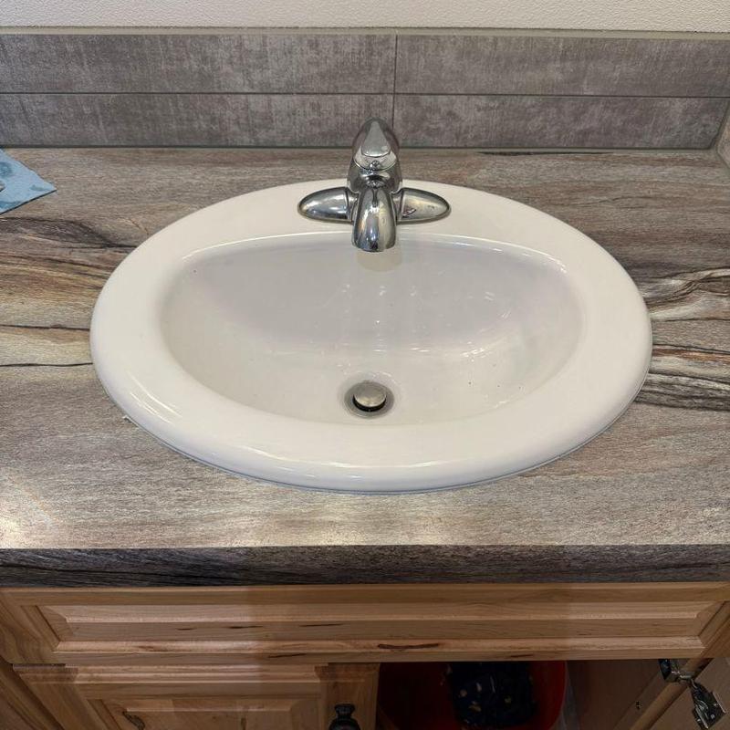 Drop-in bathroom sink with faucet installed and sealed Drop-in bathroom sink with faucet installed and sealed