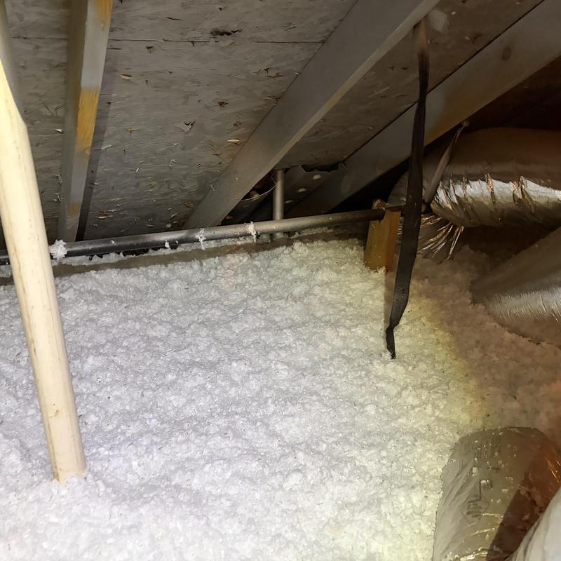 Attic insulation with ductwork and pipes visible