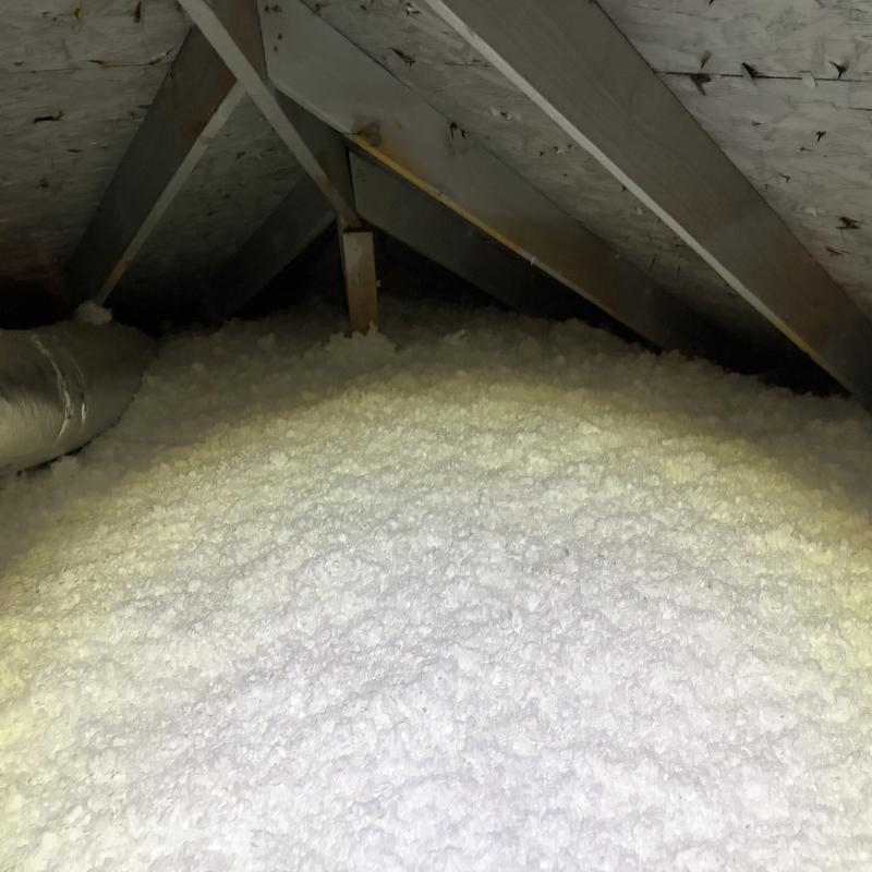 Attic spray foam insulation installation with ductwork visible