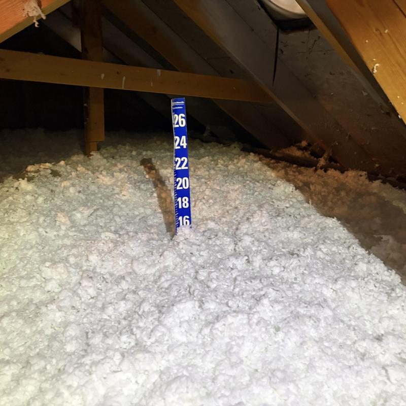 Attic loose-fill insulation with depth measurement stick