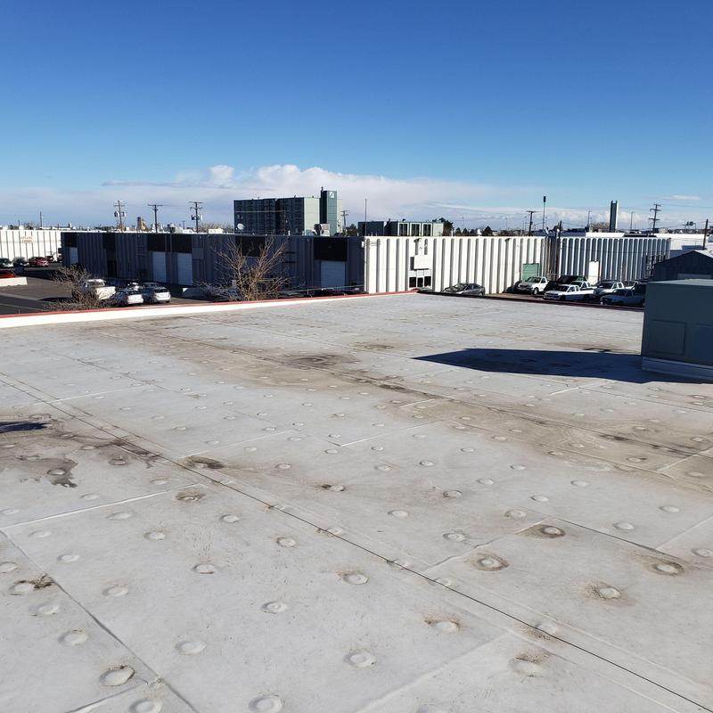 TPO flat roof with sealant spots and loose corners TPO flat roof with sealant spots and loose corners