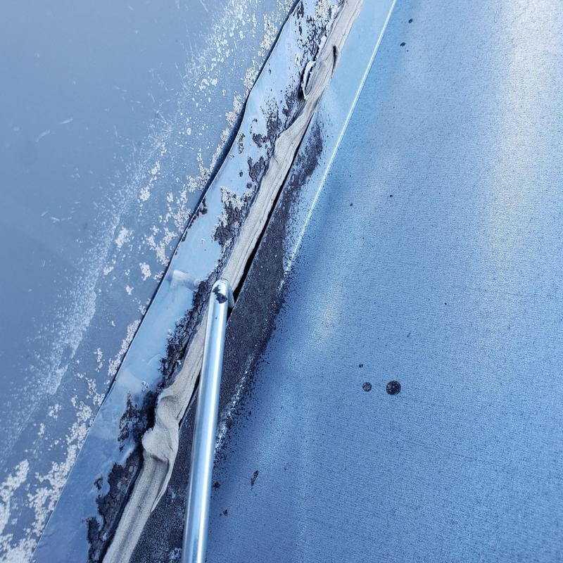 TPO flat roof seam with damaged sealant and corrosion TPO flat roof seam with damaged sealant and corrosion