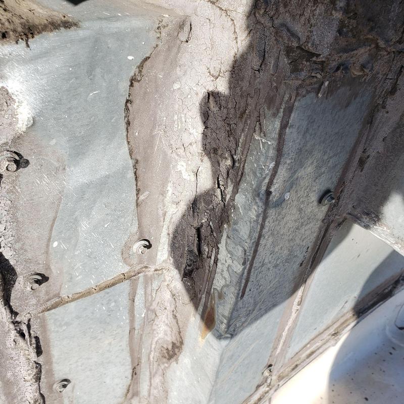 TPO flat roof corner with damaged sealant and debris TPO flat roof corner with damaged sealant and debris