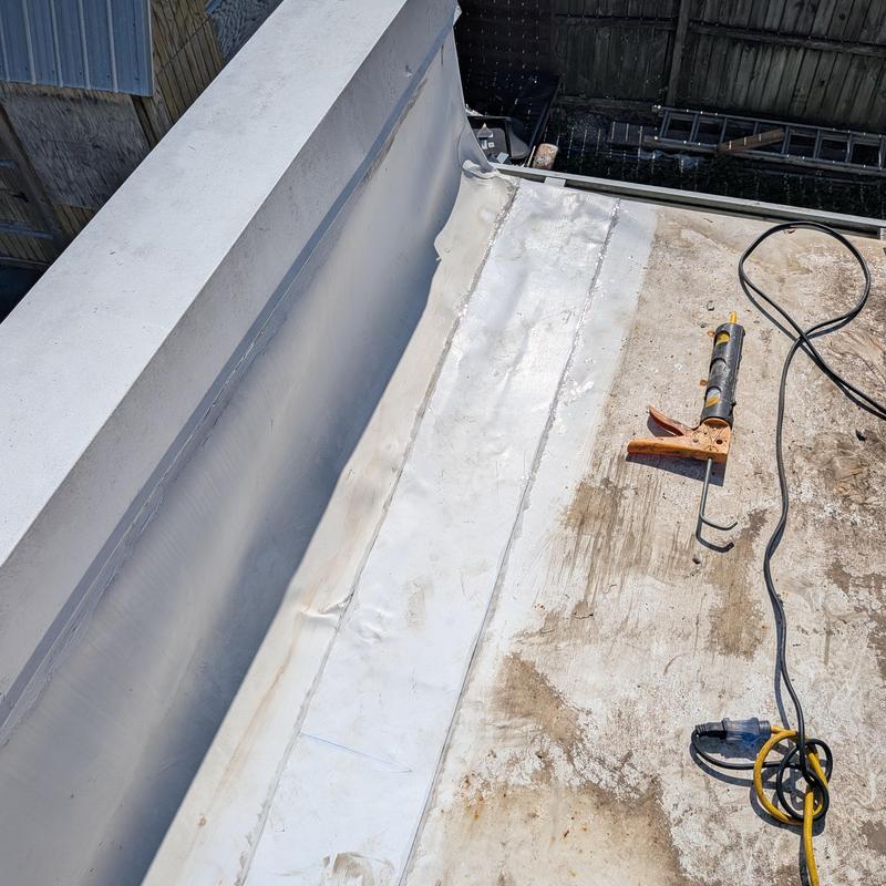 TPO flat roof seam with caulking gun and cord