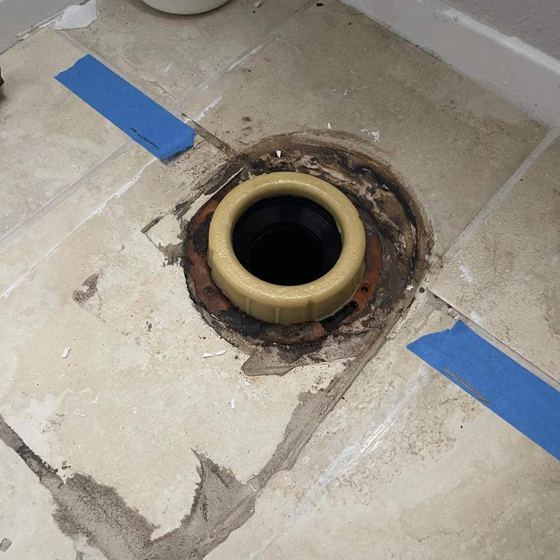 Toilet flange installation with new wax ring on tiled floor