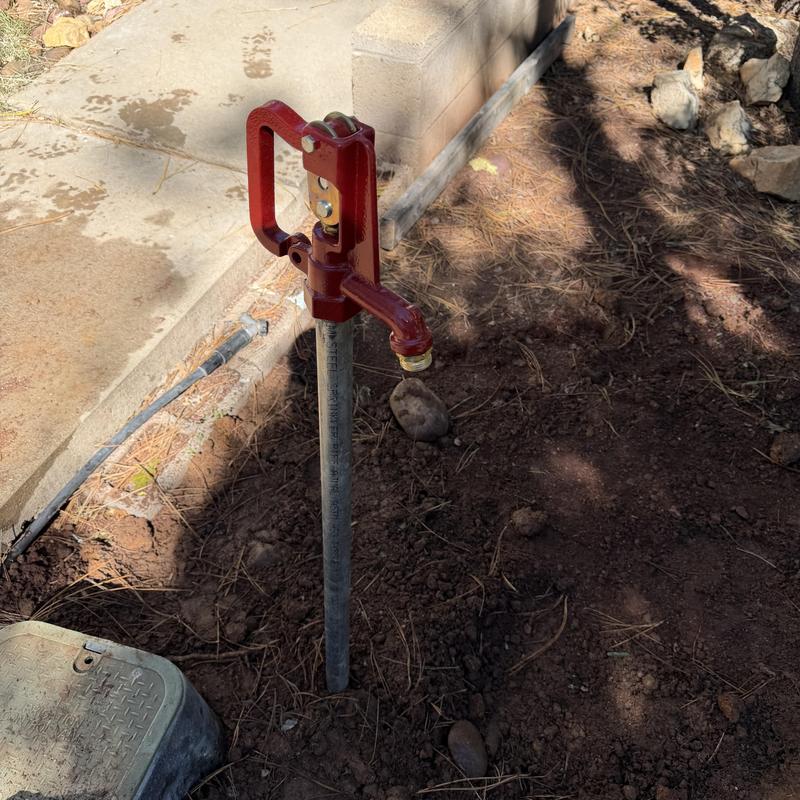 Yard hydrant with new PVC piping in soil next to sidewalk Yard hydrant with new PVC piping in soil next to sidewalk