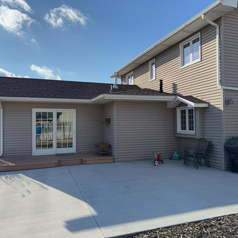 Concrete patio with adjacent siding and windows Concrete patio with adjacent siding and windows