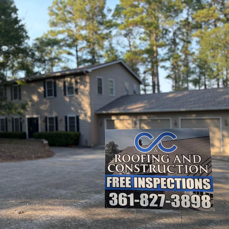 Roofing and construction company sign with contact info