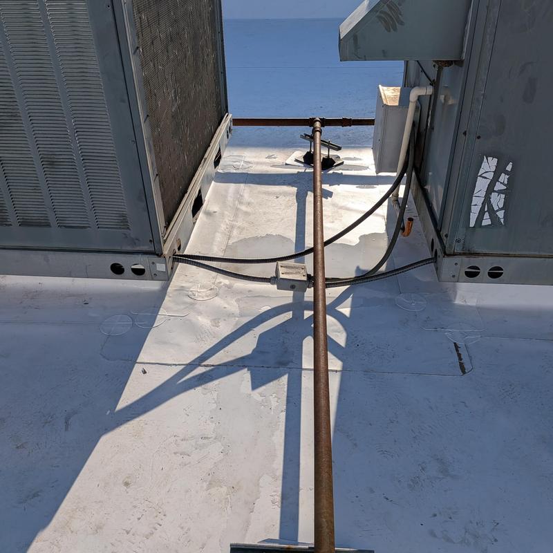 Commercial rooftop HVAC units with connecting conduit pipe